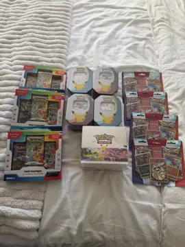 An in-store Pokémon haul laid out on a bed